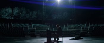 Movie still from “tick, tick... BOOM!” (2021), directed by Lin-Manuel Miranda – A man sitting at a piano in a dark room; Extreme Wide shot, High angle