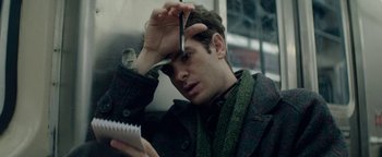 Movie still from “tick, tick... BOOM!” (2021), directed by Lin-Manuel Miranda – A man holding a pair of scissors in one hand and a notepad in the other; Close Up shot, High angle