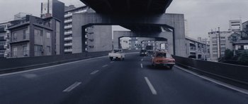 Movie still from “Solaris” (1972), directed by Andrei Tarkovsky – Cars driving down a street under a bridge; Wide shot, High angle