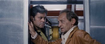 Movie still from “Solaris” (1972), directed by Andrei Tarkovsky – Two men are standing next to each other on a train; Close Up shot, Over the shoulder angle