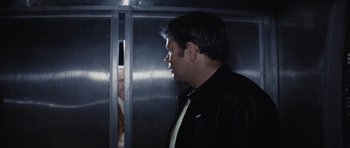 Movie still from “Solaris” (1972), directed by Andrei Tarkovsky – A man standing in front of an elevator with his head turned to the side; Medium shot, Over the shoulder angle