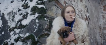 Movie still from “Solaris” (1972), directed by Andrei Tarkovsky – A woman holding a dog while smoking a cigarette; Medium shot, Low angle