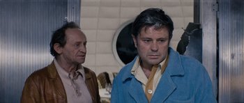 Movie still from “Solaris” (1972), directed by Andrei Tarkovsky – Two men standing next to each other in front of a wall; Medium shot, Over the shoulder angle