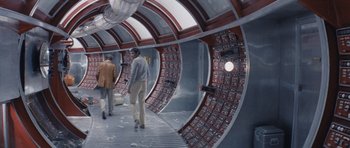 Movie still from “Solaris” (1972), directed by Andrei Tarkovsky – Two men are standing in a room that has a bunch of lights on the wall; Wide shot, High angle