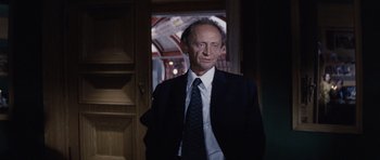 Movie still from “Solaris” (1972), directed by Andrei Tarkovsky – A man in a suit and tie standing in front of a door; Medium shot, Low angle