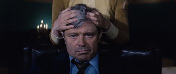 Movie still from “Solaris” (1972), directed by Andrei Tarkovsky – A man sitting in front of a woman with his hands on his head; Close Up shot, High angle