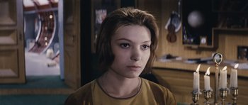 Movie still from “Solaris” (1972), directed by Andrei Tarkovsky – A young woman with short brown hair wearing a yellow shirt; Close Up shot, High angle