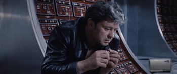 Movie still from “Solaris” (1972), directed by Andrei Tarkovsky – A man in a leather jacket is holding a pipe; Close Up shot, High angle