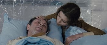 Movie still from “Solaris” (1972), directed by Andrei Tarkovsky – A young girl is helping an older man in a hospital bed; Close Up shot, High angle