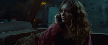 A woman sitting on a couch talking on a cell phone