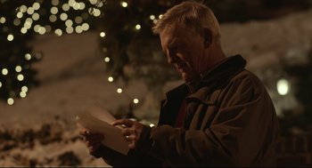 Movie still from “Spotlight” (2015), directed by Tom McCarthy – An older man holding a piece of paper in front of a christmas tree; Close Up shot, Over the shoulder angle
