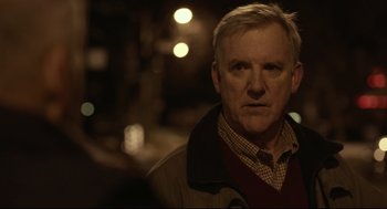 Movie still from “Spotlight” (2015), directed by Tom McCarthy – An older man in a brown jacket is looking at the camera; Close Up shot, Over the shoulder angle