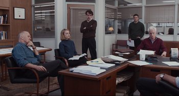 Movie still from “Spotlight” (2015), directed by Tom McCarthy – A group of people sitting at a table in an office; Wide shot, High angle