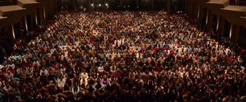 Movie still from “Steve Jobs” (2015), directed by Danny Boyle – A crowd of people sitting in a large auditorium; Extreme Wide shot, High angle