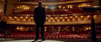 Movie still from “Steve Jobs” (2015), directed by Danny Boyle – A man standing in front of an audience in an auditorium; Extreme Wide shot, Low angle