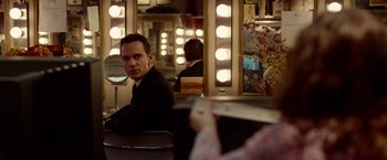 Movie still from “Steve Jobs” (2015), directed by Danny Boyle – A man sitting in front of a mirror in a dressing room; Medium shot, Over the shoulder angle