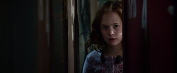 Movie still from “Steve Jobs” (2015), directed by Danny Boyle – A young girl standing in front of a mirror; Close Up shot, Over the shoulder angle