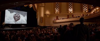 Movie still from “Steve Jobs” (2015), directed by Danny Boyle – A crowd of people in a large auditorium; Extreme Wide shot, High angle