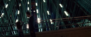 Movie still from “Steve Jobs” (2015), directed by Danny Boyle – A man in a black suit is standing in front of some lights; Extreme Wide shot, Low angle