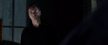 Movie still from “Steve Jobs” (2015), directed by Danny Boyle – A man standing in the dark looking at the camera; Close Up shot, Low angle