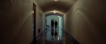 Movie still from “Steve Jobs” (2015), directed by Danny Boyle – Two men are walking down a hallway in a building; Wide shot, Low angle