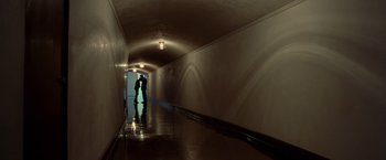 Movie still from “Steve Jobs” (2015), directed by Danny Boyle – Two people are standing in a hallway of a building; Wide shot, Low angle