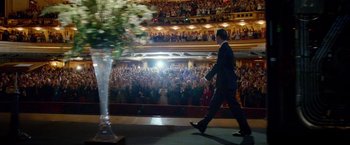 Movie still from “Steve Jobs” (2015), directed by Danny Boyle – A man walking on a stage in front of an audience; Extreme Wide shot, Low angle