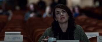 Movie still from “Steve Jobs” (2015), directed by Danny Boyle – A woman sitting at a table with a cup of coffee; Close Up shot, Over the shoulder angle