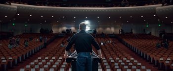 Movie still from “Steve Jobs” (2015), directed by Danny Boyle – A man standing in front of an audience in an auditorium; Wide shot, Low angle