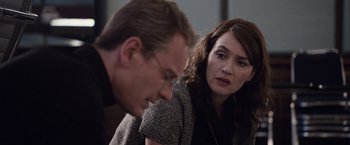 Movie still from “Steve Jobs” (2015), directed by Danny Boyle – A man and a woman sitting next to each other; Close Up shot, Over the shoulder angle