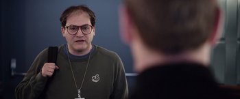 Movie still from “Steve Jobs” (2015), directed by Danny Boyle – A man with glasses is looking at himself in the mirror; Close Up shot, Over the shoulder angle