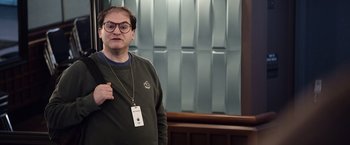 Movie still from “Steve Jobs” (2015), directed by Danny Boyle – A man with glasses is standing in front of a wall; Medium shot, Over the shoulder angle