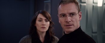 Movie still from “Steve Jobs” (2015), directed by Danny Boyle – A man and a woman standing next to each other; Close Up shot, Over the shoulder angle
