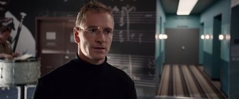 Movie still from “Steve Jobs” (2015), directed by Danny Boyle – A man wearing glasses standing in front of a chalkboard; Close Up shot, Over the shoulder angle