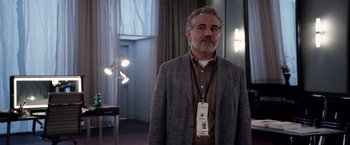 Movie still from “Steve Jobs” (2015), directed by Danny Boyle – A man in a suit and tie standing in front of a window; Medium shot, Over the shoulder angle