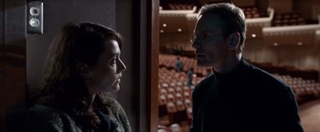 Movie still from “Steve Jobs” (2015), directed by Danny Boyle – A man and a woman standing next to each other in front of an auditorium; Close Up shot, Over the shoulder angle