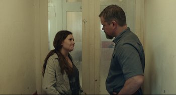 Movie still from “Stillwater” (2021), directed by Tom McCarthy – A man and a woman standing next to each other in a room; Medium shot, Over the shoulder angle