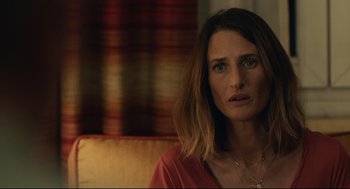 Movie still from “Stillwater” (2021), directed by Tom McCarthy – A person sitting on a couch; Close Up shot, Over the shoulder angle