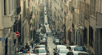 Movie still from “Stillwater” (2021), directed by Tom McCarthy – A street filled with lots of cars and people walking down it; Extreme Wide shot, High angle