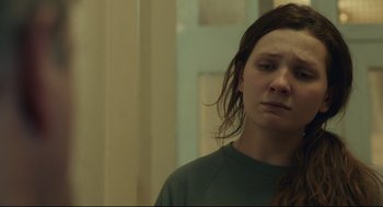 Movie still from “Stillwater” (2021), directed by Tom McCarthy – A woman standing in a room with her eyes wide open; Close Up shot, Over the shoulder angle