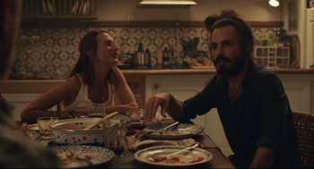 Movie still from “Stillwater” (2021), directed by Tom McCarthy – A man and a woman sitting at a dinner table; Medium shot, Over the shoulder angle