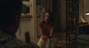 Movie still from “Stillwater” (2021), directed by Tom McCarthy – A woman sitting on the floor of a kitchen; Medium shot, Over the shoulder angle