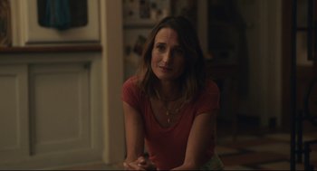 Movie still from “Stillwater” (2021), directed by Tom McCarthy – A woman sitting on the ground in a room; Close Up shot, Over the shoulder angle