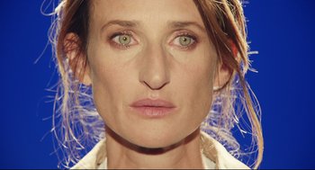 Movie still from “Stillwater” (2021), directed by Tom McCarthy – A person's face on a blue background; Close Up shot, Overhead angle