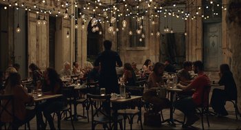 Movie still from “Stillwater” (2021), directed by Tom McCarthy – A group of people sitting at tables in a restaurant; Extreme Wide shot, Over the shoulder angle