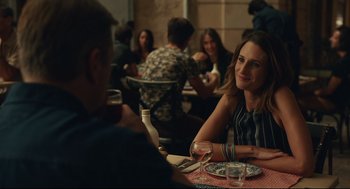 Movie still from “Stillwater” (2021), directed by Tom McCarthy – A woman sitting at a table with a glass of wine; Medium shot, Over the shoulder angle