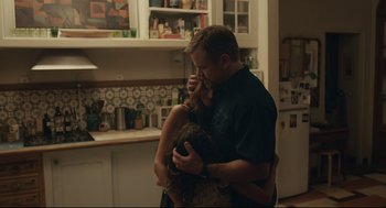 Movie still from “Stillwater” (2021), directed by Tom McCarthy – A man and a woman hugging in a kitchen; Medium shot, Over the shoulder angle