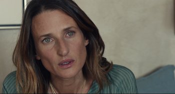 Movie still from “Stillwater” (2021), directed by Tom McCarthy – A woman's face in a green shirt; Close Up shot, High angle