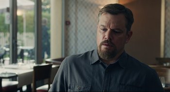 Movie still from “Stillwater” (2021), directed by Tom McCarthy – A person with a beard wearing a gray shirt; Close Up shot, Over the shoulder angle