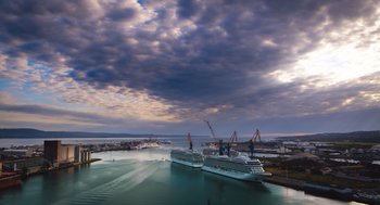 Movie still from “Belfast” (2021), directed by Kenneth Branagh – Two cruise ships docked in a harbor under a cloudy sky; Extreme Wide shot, Low angle